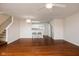 Open-concept living room with hardwood floors, stairs, and a view of the kitchen area at 11475 Clay Ct # 102, Fishers, IN 46037