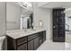 Stylish bathroom with dark vanity and fixtures, featuring white tiled flooring and a large mirror at 11941 Sand Dollar Cir, Indianapolis, IN 46256