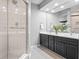 A modern bathroom with a glass-enclosed shower and a double vanity with sleek countertops at 11941 Sand Dollar Cir, Indianapolis, IN 46256