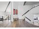 Well-lit foyer area with hardwood floors, modern staircase, and an open view to the adjacent living spaces at 11941 Sand Dollar Cir, Indianapolis, IN 46256