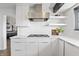 Bright kitchen featuring white cabinets, stainless steel hood, subway tile backsplash, and gas cooktop at 11941 Sand Dollar Cir, Indianapolis, IN 46256