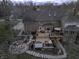 Aerial view of a brick home's backyard featuring a hot tub and outdoor seating area with a fire pit at 12065 Watermark Ct, Indianapolis, IN 46236