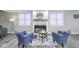Cozy basement seating area with two blue chairs, decorative fireplace, and stylish decor at 12065 Watermark Ct, Indianapolis, IN 46236