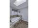 Bright bathroom featuring a tub with tiled surround, skylight and tiled floors at 12065 Watermark Ct, Indianapolis, IN 46236
