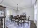 Spacious dining room with dark wood floors, tray ceiling, a chandelier, and doorway view into another room at 12065 Watermark Ct, Indianapolis, IN 46236