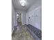 Inviting hallway featuring tiled floors, a comfortable bench, and stylish wall accents with coat hooks at 12065 Watermark Ct, Indianapolis, IN 46236