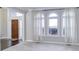 Bright living room boasts large windows with arched details, a view of the front door, and neutral carpet flooring at 12065 Watermark Ct, Indianapolis, IN 46236