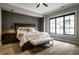 Beautiful bedroom featuring a large bed, dark wood furniture, and a black-framed window at 12099 Sigillary Way, Carmel, IN 46032