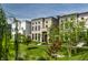 Attractive townhomes with brick facades and black framed windows set amongst green lawns and young trees at 12099 Sigillary Way, Carmel, IN 46032