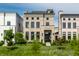 Attractive townhome with brick facade, black framed windows, well manicured lawn, and neatly landscaped flowerbeds at 12099 Sigillary Way, Carmel, IN 46032