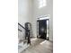 Bright foyer with a dark door, beautiful mirror, stylish staircase, and lovely wood flooring at 12099 Sigillary Way, Carmel, IN 46032