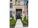Inviting front door with sidelights, potted plants, and an address marker located above well landscaped flowerbeds at 12099 Sigillary Way, Carmel, IN 46032
