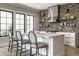Modern kitchen featuring stainless steel appliances, a brick backsplash, a center island, and wood floors at 12099 Sigillary Way, Carmel, IN 46032