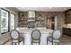 Bright kitchen with a white center island, stainless vent hood, brick backsplash, and open shelving at 12099 Sigillary Way, Carmel, IN 46032