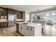 Open concept kitchen with stainless steel refrigerator and a white island with sink and bar seating at 12099 Sigillary Way, Carmel, IN 46032