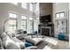 Spacious living room with a fireplace, a plush sofa, large windows, and a decorative coffee table at 12099 Sigillary Way, Carmel, IN 46032