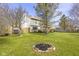 Well-maintained backyard features a fire pit, mature trees, a swing, and a wooden fence at 12161 Pebblebrooke Ct, Indianapolis, IN 46236