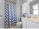 Neutral bathroom featuring a vanity, toilet, and shower with patterned blue curtain at 12161 Pebblebrooke Ct, Indianapolis, IN 46236