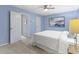 Bright bedroom with blue walls, ceiling fan, and adjacent closet for clothing storage at 12161 Pebblebrooke Ct, Indianapolis, IN 46236