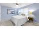 Bright bedroom with blue walls, ceiling fan, and a large window at 12161 Pebblebrooke Ct, Indianapolis, IN 46236