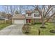 Inviting two-story home with an attached garage, landscaped front yard, and charming red door at 12161 Pebblebrooke Ct, Indianapolis, IN 46236