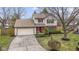 View of a two-story home with red shutters, an attached garage, and a beautifully landscaped yard at 12161 Pebblebrooke Ct, Indianapolis, IN 46236