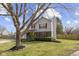 This home has a lush lawn and mature trees, complemented by red shutters and an attached garage at 12161 Pebblebrooke Ct, Indianapolis, IN 46236