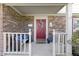 Cozy front porch with a red door, brick detailing, and decorative wreath, creating a welcoming entrance at 12161 Pebblebrooke Ct, Indianapolis, IN 46236