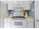 White range with oven and cooktop with range hood and white cabinets at 12161 Pebblebrooke Ct, Indianapolis, IN 46236