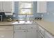 Bright kitchen featuring a stainless steel sink, white cabinets, and natural light from the window at 12161 Pebblebrooke Ct, Indianapolis, IN 46236