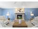 Bright living room featuring a stone fireplace, lamps, and a wooden coffee table at 12161 Pebblebrooke Ct, Indianapolis, IN 46236