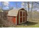 Red shed with cream trim and a tan roof adds charm and practicality to the yard at 12161 Pebblebrooke Ct, Indianapolis, IN 46236
