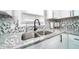Close-up of a modern kitchen sink with granite countertops and stylish tiled backsplash at 1444 English Ave, Indianapolis, IN 46201