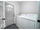 Functional laundry room with modern washer and dryer, a door to the outside, and geometric flooring at 1444 English Ave, Indianapolis, IN 46201