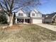 Two-story house with neutral siding, brick accents, and a two-car garage and a manicured lawn with trees at 14466 Chapelwood Ln, Fishers, IN 46037