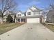 Charming two-story home featuring a brick and vinyl exterior, attached two-car garage, and a well-manicured front yard at 14466 Chapelwood Ln, Fishers, IN 46037