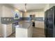Modern kitchen features white cabinetry, gray countertops, stainless steel appliances, and a convenient center island at 14466 Chapelwood Ln, Fishers, IN 46037