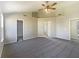 Airy main bedroom showcases a ceiling fan, tray ceiling, carpeted floors and ensuite bathroom and walk-in closet entries at 14466 Chapelwood Ln, Fishers, IN 46037