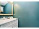 Bathroom features a white vanity with sink, decorative mirror and teal painted walls at 1464 Hession Dr, Brownsburg, IN 46112