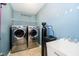 Functional laundry room is equipped with modern washer and dryer, utility sink and storage space at 1464 Hession Dr, Brownsburg, IN 46112
