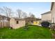 Large, green backyard with a shed, patio, and grill area, enclosed by a wooden fence at 14974 Dry Creek Rd, Noblesville, IN 46060