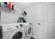 Bright laundry room with white Samsung washer and dryer, storage shelves, and a white door at 14974 Dry Creek Rd, Noblesville, IN 46060
