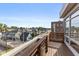 Balcony with a wooden floor overlooking a neighborhood with blue houses under a clear sky at 1529 Alabama N St # H, Indianapolis, IN 46202