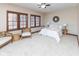 Bright bedroom with large windows, neutral carpet, ceiling fan, and accent furniture and decor at 1529 Alabama N St # H, Indianapolis, IN 46202