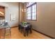 Bright dining area with wooden table, black chairs, light fixture, and a large arched window with natural light at 1529 Alabama N St # H, Indianapolis, IN 46202