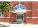 Close-up of a red brick building's entrance with arched window, double doors, and building number 1529 at 1529 Alabama N St # H, Indianapolis, IN 46202