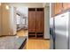 View of kitchen island with granite countertop and stainless steel refrigerator, and built-in wooden storage at 1529 Alabama N St # H, Indianapolis, IN 46202