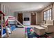 Fun bedroom with playful striped wallpaper, bunkbed with slide, colorful rug, and cozy armchair at 1591 Preston Trl, Carmel, IN 46032