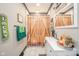 Well-lit bathroom features vanity with white cabinets and wood-style shower curtain at 1815 Pearl St, Anderson, IN 46016