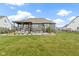 Spacious back yard with a stone patio, outdoor kitchen, and a covered porch at 18271 Lake Winds Dr, Westfield, IN 46074
